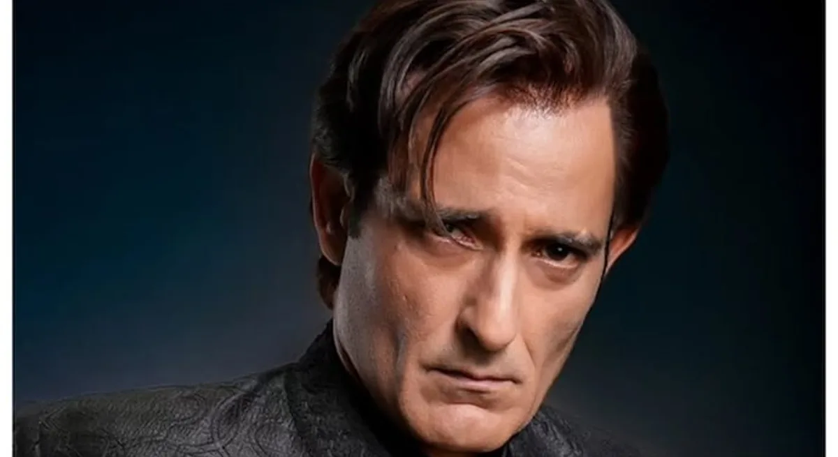 Akshaye Khanna as Rehman Dakait in Dhurandhar — black outfit, aviators, mid-gesture before a desert backdrop